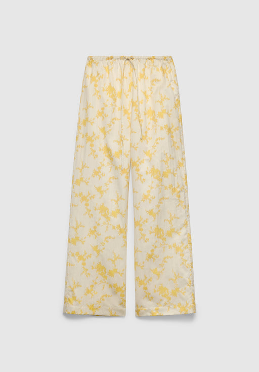 A pair of cream-colored wide-leg pants with a relaxed fit, featuring an elastic waistband with a drawstring and a delicate yellow floral print, displayed against a plain background.
