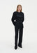 Full-length front view of a woman wearing a black long-sleeve top and matching tailored trousers, showcasing a sleek, fitted silhouette with a smooth finish against a plain studio background.