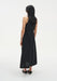 Back view of a sleeveless black midi dress with a clean A-line silhouette, worn with black low heels.