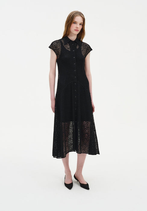 Full-length front view of a woman wearing a black semi-sheer lace midi dress with a collared neckline, button-down front, and cap sleeves, styled with black pointed heels in a minimal studio setting.