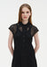 Close-up front view of a woman wearing a black semi-sheer lace dress with a pointed collar, button-down front, and cap sleeves, highlighting the delicate lace texture and panel detailing.